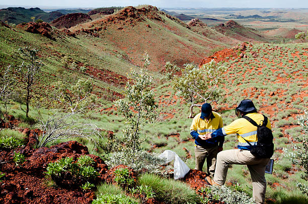 Pilbara, Australia - March 18, 2011: Geologists sampling rocks in iron ore exploration in the Outback